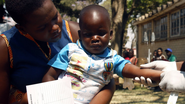 A health worker attends to a child suffering from cholera symptoms in Harare.