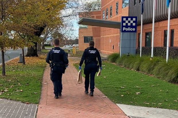 Police seen carrying items following a raid in Lucyvale.