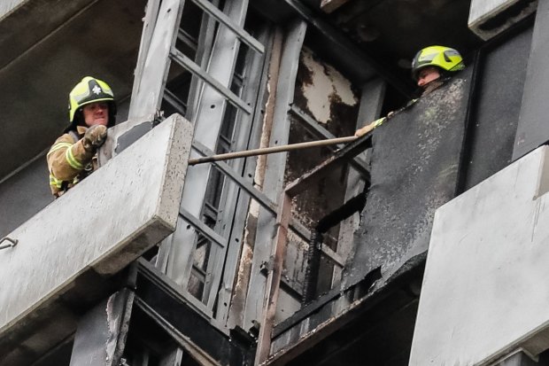 Firefighters survey the damage on the Neo 200 tower block in Melbourne's Spencer Street.