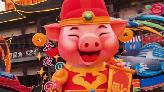 Women take a selfie as others tour at the Yu Garden decorated with pig statues for Lunar New Year in Shanghai on Saturday. The latest economic figures show China's middle class is rapidly expanding.