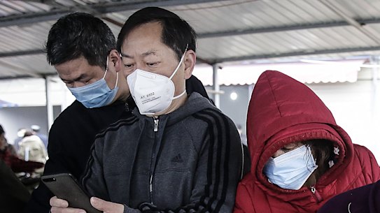 Wuhan residents wear masks to buy vegetables.