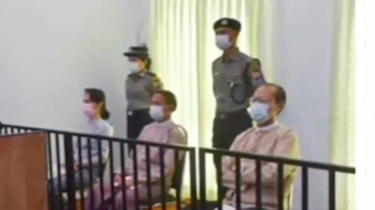 Deposed Myanmar leader Aung San Suu Kyi, left, was shown on TV sitting in court.