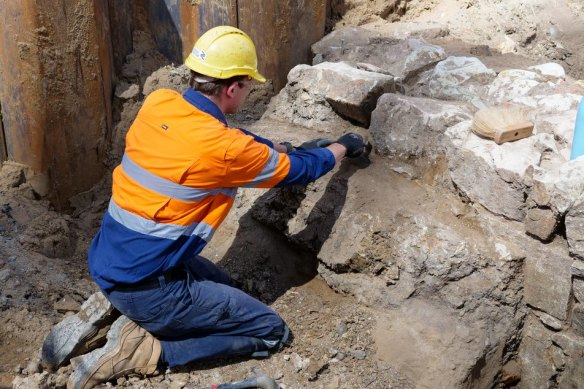 A worker inspects a 30-metre drystone wall discovered under Adelaide Street.