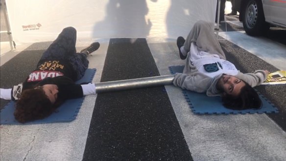 Two climate change activists glued themselves to a pedestrian crossing on Queen Street on Tuesday.