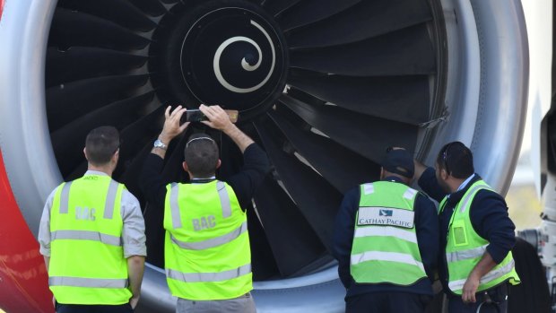 Safety Inspectors look over the engine of AirAsia flight D7207 at Brisbane Airport after a bird strike in July, 2017.