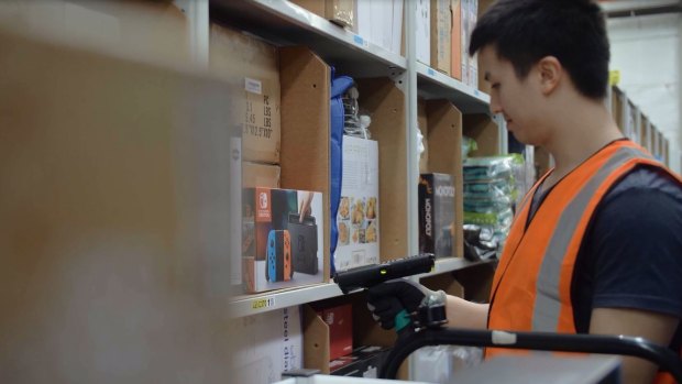An Amazon worker at its Melbourne fulfillment centre with one of the handheld scanners.