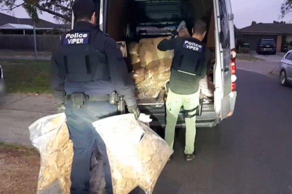 Police loading tobacco bales seized in Delahey during raids across the state in July.