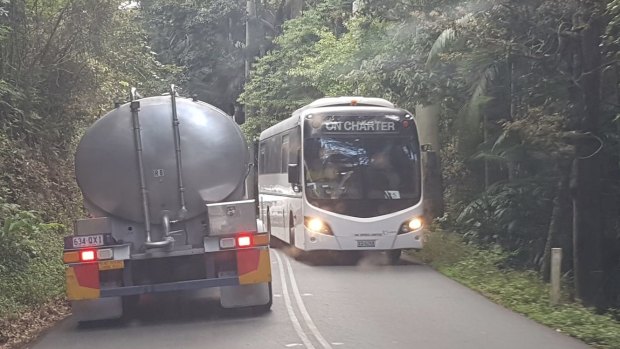 A water carrier passes a tourist bus on Tamborine Mountain.