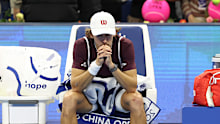 Alex De Minaur of Australia reacts after retiring injured.