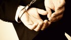 Businessman hand cuffed, close-up toned image