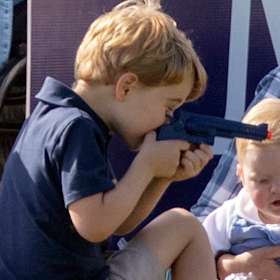 Prince George plays with toy gun at the polo
