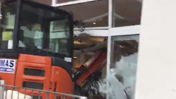 Wreaking havoc: A bulldozer drives through the front of a Travelodge.