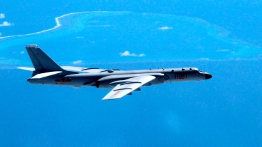 In this undated photo released by Xinhua News Agency, a Chinese H-6K bomber patrols the islands and reefs in the South China Sea. 