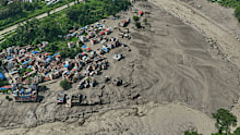 Damaged houses stand precariously near the swollen, debris-choked banks of the Trishuli River after flash floods in Nepal’s Nuwakot district on Wednesday, Aug. 26, 2026. (AP Photo/Niranjan Shrestha)