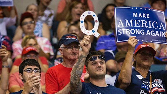 A supporter of President Donald Trump holds up a sign referencing QAnon.