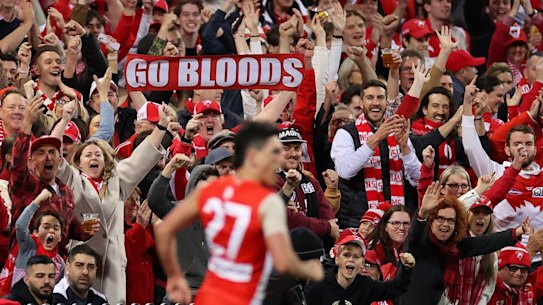Swans fans celebrate as JustinÂ McInerney of the Swans kicks a goal.