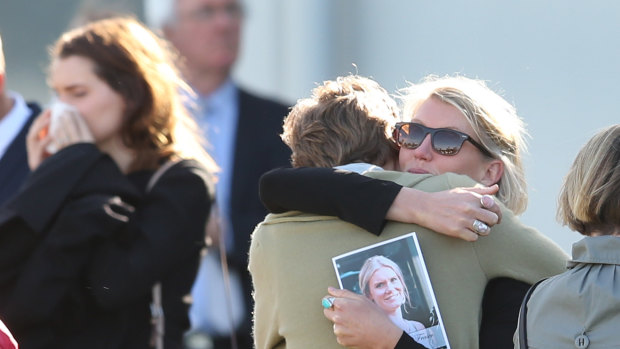 Mourners embraced after the memorial service ended. 