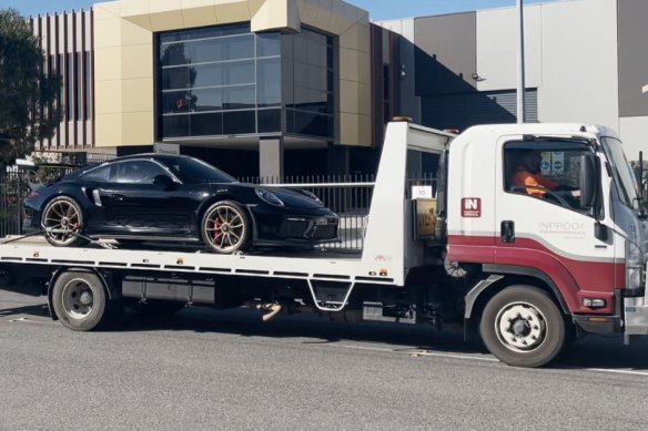 A Porsche is seized from the Somerton warehouse on Thursday.