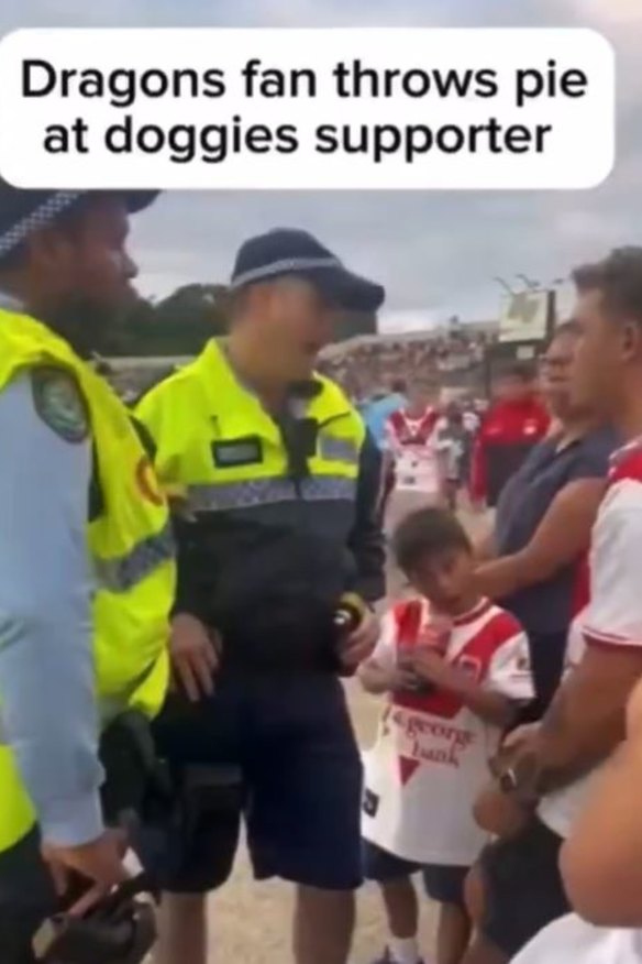 Police officers speak to a Dragons fan after a pie was thrown at Canterbury supporters.