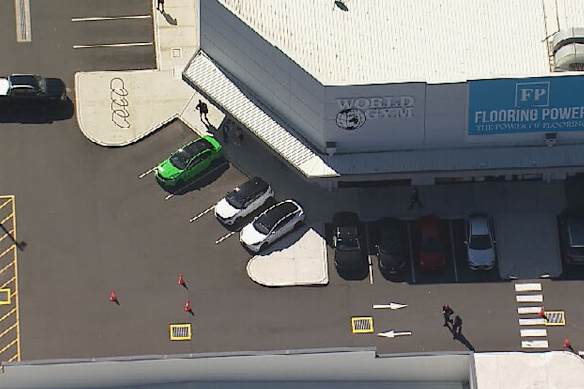 A polícia isola uma área do estacionamento em frente ao World Gym. 