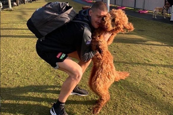 Darcy Cameron farewells his dog before the Pies leave for their hub. 