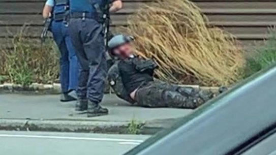 A screenshot from a video showing police arresting accused gunman Brenton Tarrant.