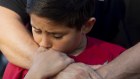 Robbie Ramirez, 10, holds onto his father, Robert Ramirez, at a vigil for victims of the shooting at the Gilroy Garlic Festival on July 29. 