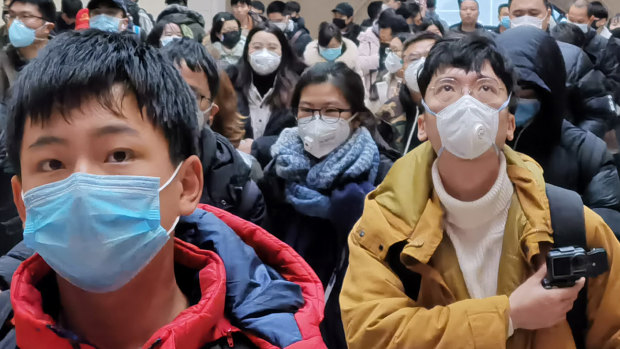 People wear face masks as they wait at Hankou Railway Station in Wuhan last week. 
