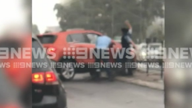 Police attempt to smash the windscreen of a car before a man is arrested at Gymea on Friday.