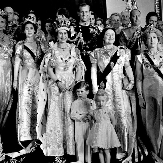 Queen Elizabeth II in her coronation robes with her sister Margaret (left of her), husband and mother (right), children Charles and Anne, and other family members in 1953.