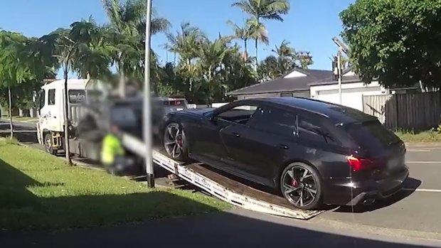 One of the luxury cars is loaded onto tow trucks in the Gold Coast suburb of Bundall.