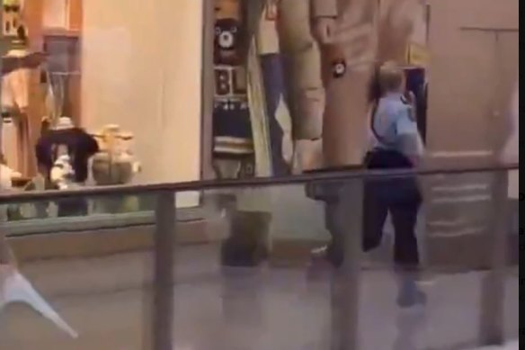 A police officer running through the shopping centre amid reports of a stabbing. 