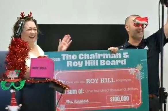 Gina Rinehart delivers a $100,000 cheque to a lucky employee.