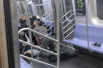 A person is aided in a subway car in the Brooklyn borough of New York.