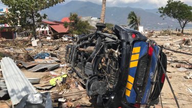 A car lays on its side among the rubble at Talise beach, Palu.