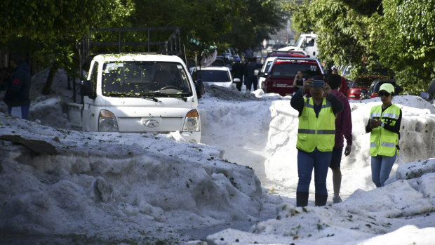Residents of Guadalajara, Mexico, take pictures of the streets filled with hail. 