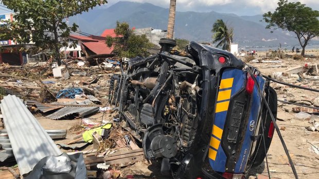 A car lays on its side among the rubble at Talise beach, Palu.