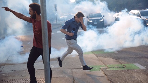 Nine reporter Tim Arvier runs from police tear gas amid protests in Minneapolis over the police killing of George Floyd.