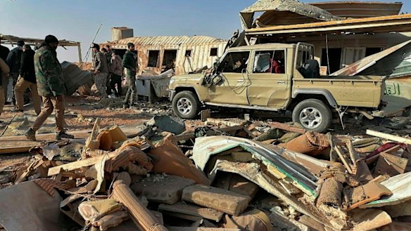 Fighters from the Kataeb Hezbollah, or Hezbollah Brigades militia, inspect the destruction at their headquarters in the aftermath of a US airstrike in Qaim, Iraq, on Monday.