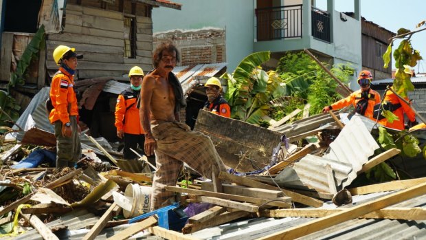 Daeng Fajar, centre, with an evacuation team looks for the young daughter of a street seller in the rubble at Talise, Palu, Sulawesi.. "We are not blood related, but she's family."