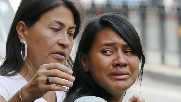 Barbara Barca, right, a survivor of the stampede at a crowded nightclub, cries as she leaves police headquarters in Caracas, Venezuela, on Saturday.