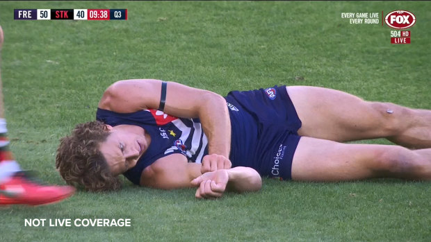 Fremantle star Nat Fyfe has been helped off the field by trainers after a brutal head clash with an opponent left him floored