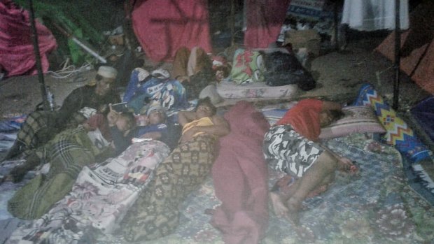 Villagers sleep outside their tents afraid of more aftershocks in Teluk Koombal, Lombok on Sunday.