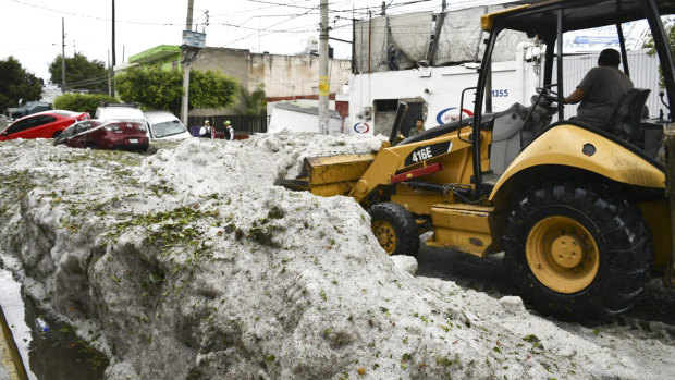 A bulldozer attempts to clear some of the hail. 