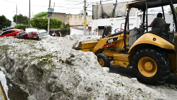 A bulldozer attempts to clear some of the hail. 