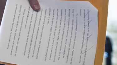 El senador Bill Cassidy sostiene un documento que indica que se está preparando para votar para absolver a Donald Trump.