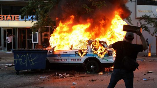A Chicago police vehicle is set on fire during violent protests Saturday, May 30, 2020, as outrage builds over the killing of George Floyd, a black man who died in Minneapolis on May 25 after a police officer pressed his knee into his neck for several minutes. (Ashlee Rezin Garcia/Chicago Sun-Times via AP)
