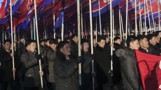North Koreans parade with the North Korean flag in Kim Il Sung Square in Pyongyang, North Korea.