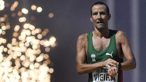 Portugal's Joao Vieira crosses the finish line second during the men's 50 kilometer walk – a race he described as 'hell' due to the heat.