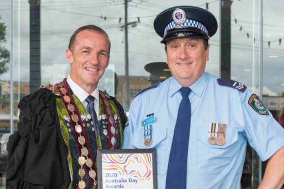 Police officer David John Henderson, right, accepts an award for citizen of the year in 2020 in Lismore, with then-mayor Isaac Smith.